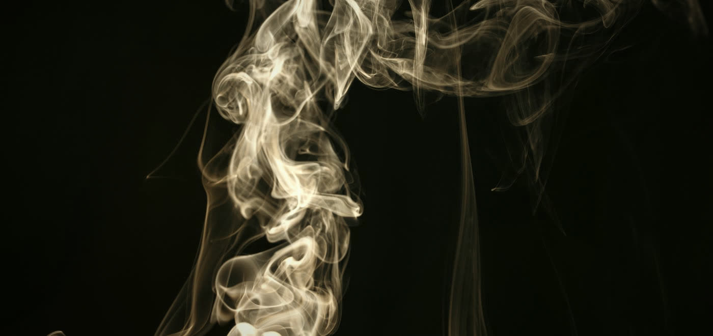 Abstract white smoke curling in the dark